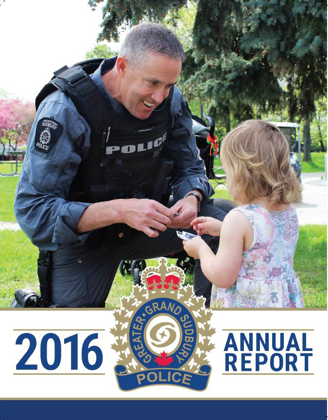 Man officer crouching down to hand a small child a sticker