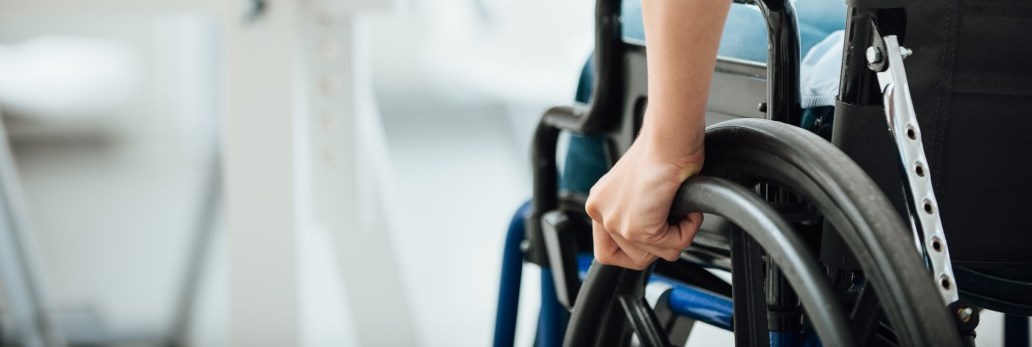 person's hand on wheel chair