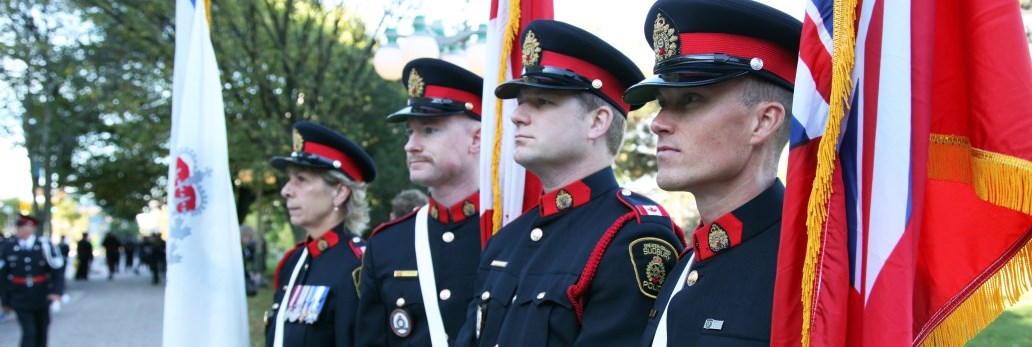 uniformed officers holding flags and looking into the distance