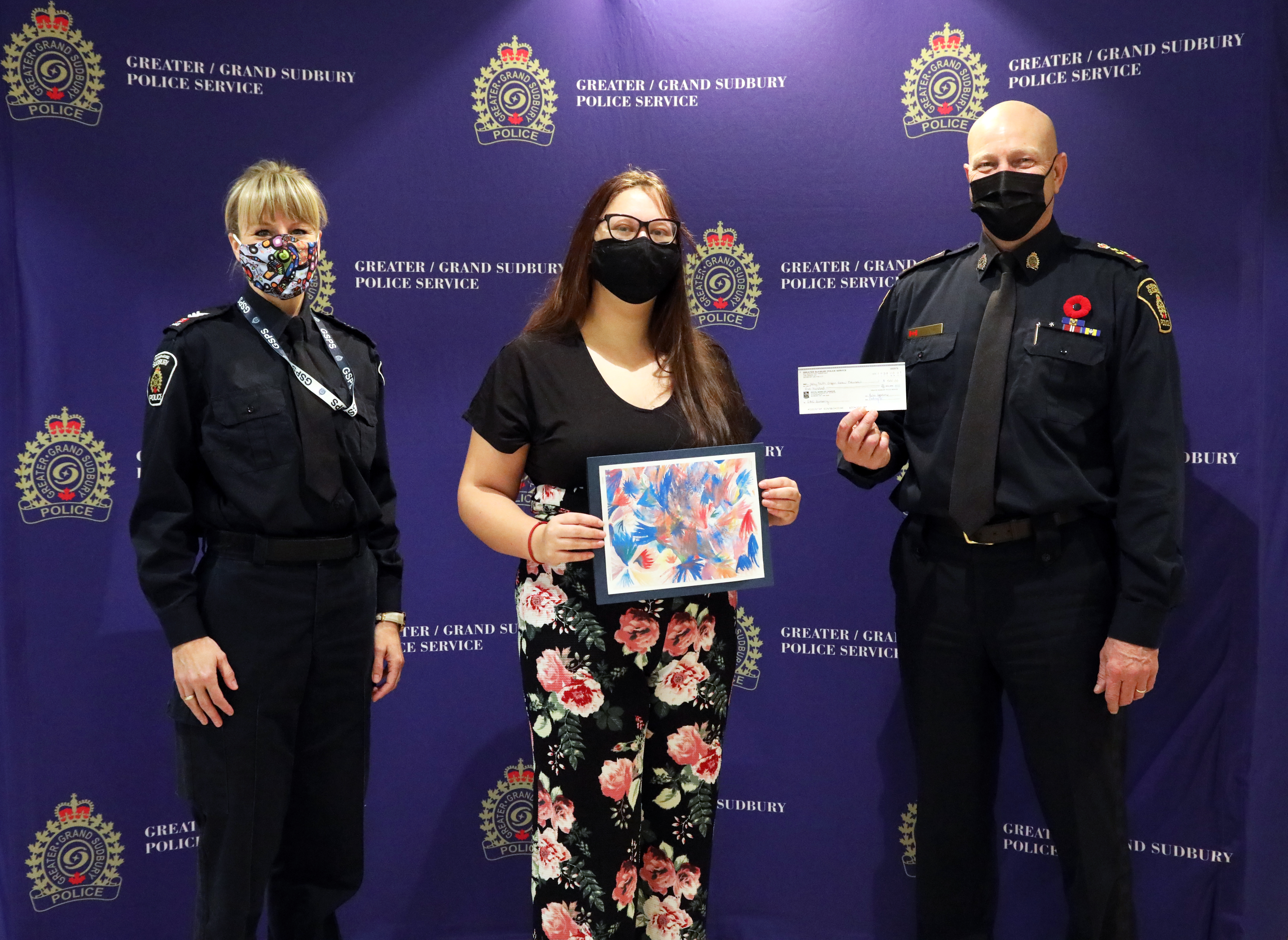 female officer and young woman and Chief of Police posing for award ceremony