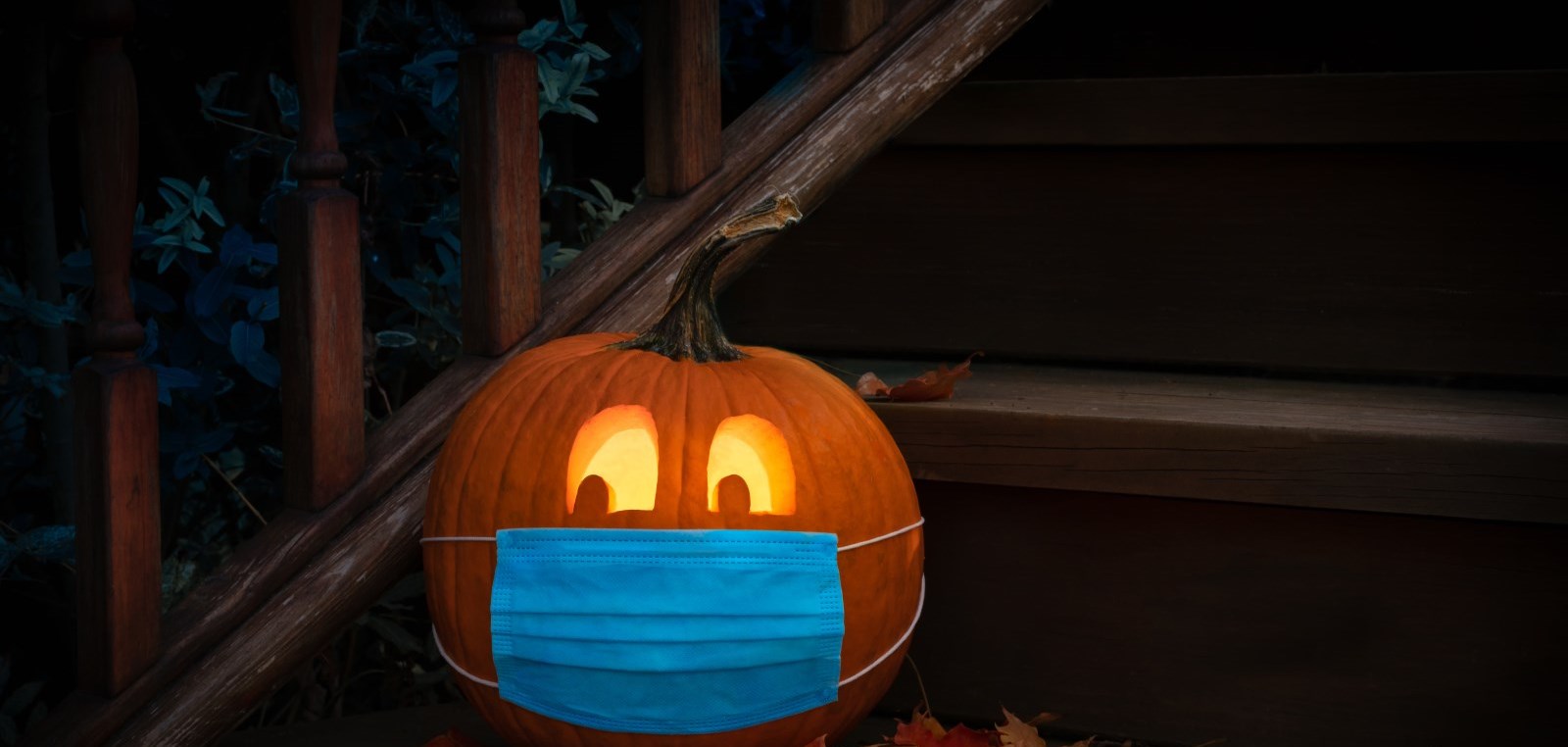 pumpkin on doorstep wearing face mask