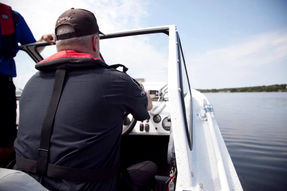 Police Officer driving boat on lake water