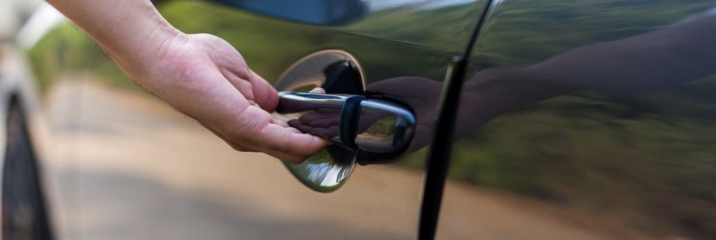 person's hand opening car door handle