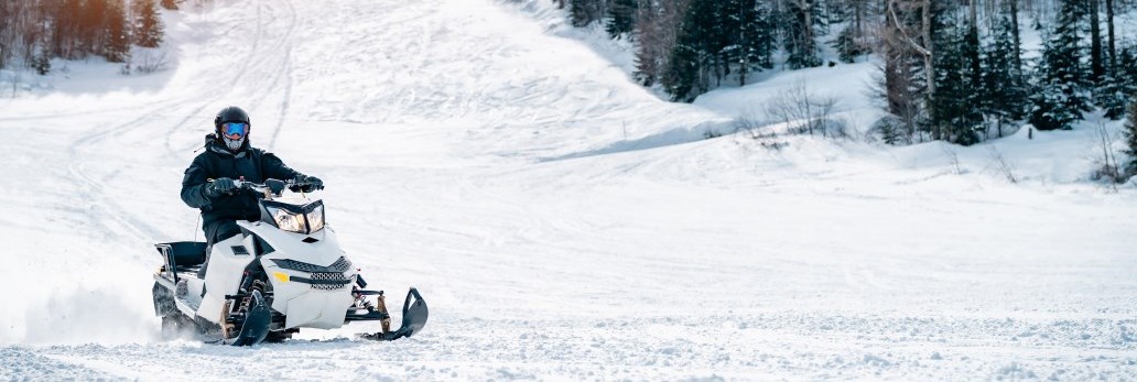 snowmobiler riding on winter trail