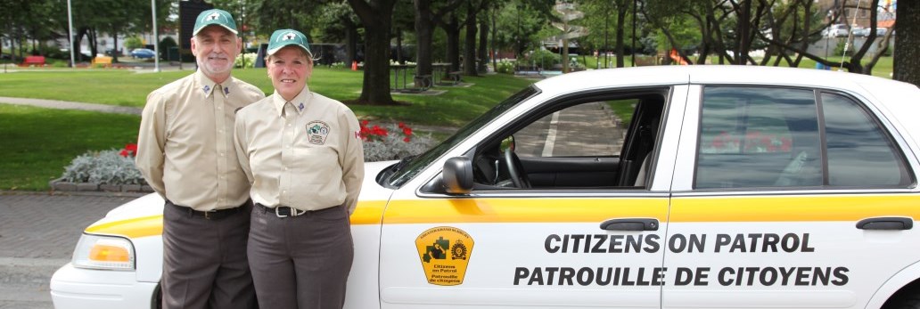 man and woman standing beside Citizens on Patrol vehicle