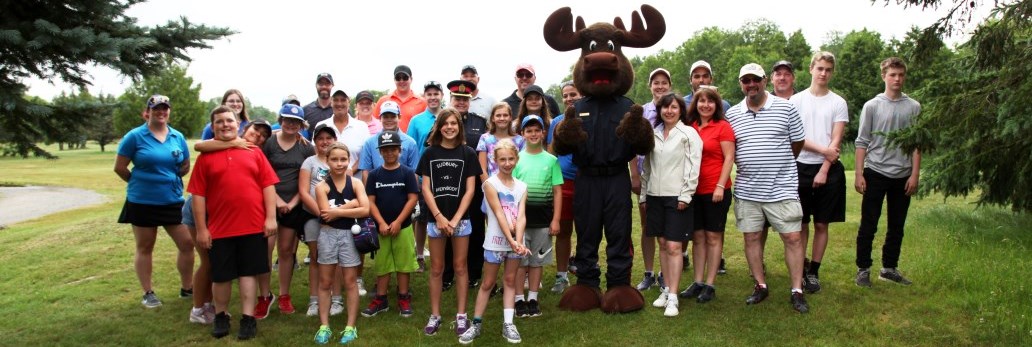 group of children and police volunteers standing on golf course