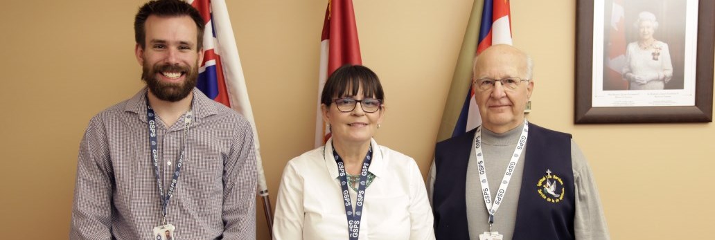 three people standing and smiling