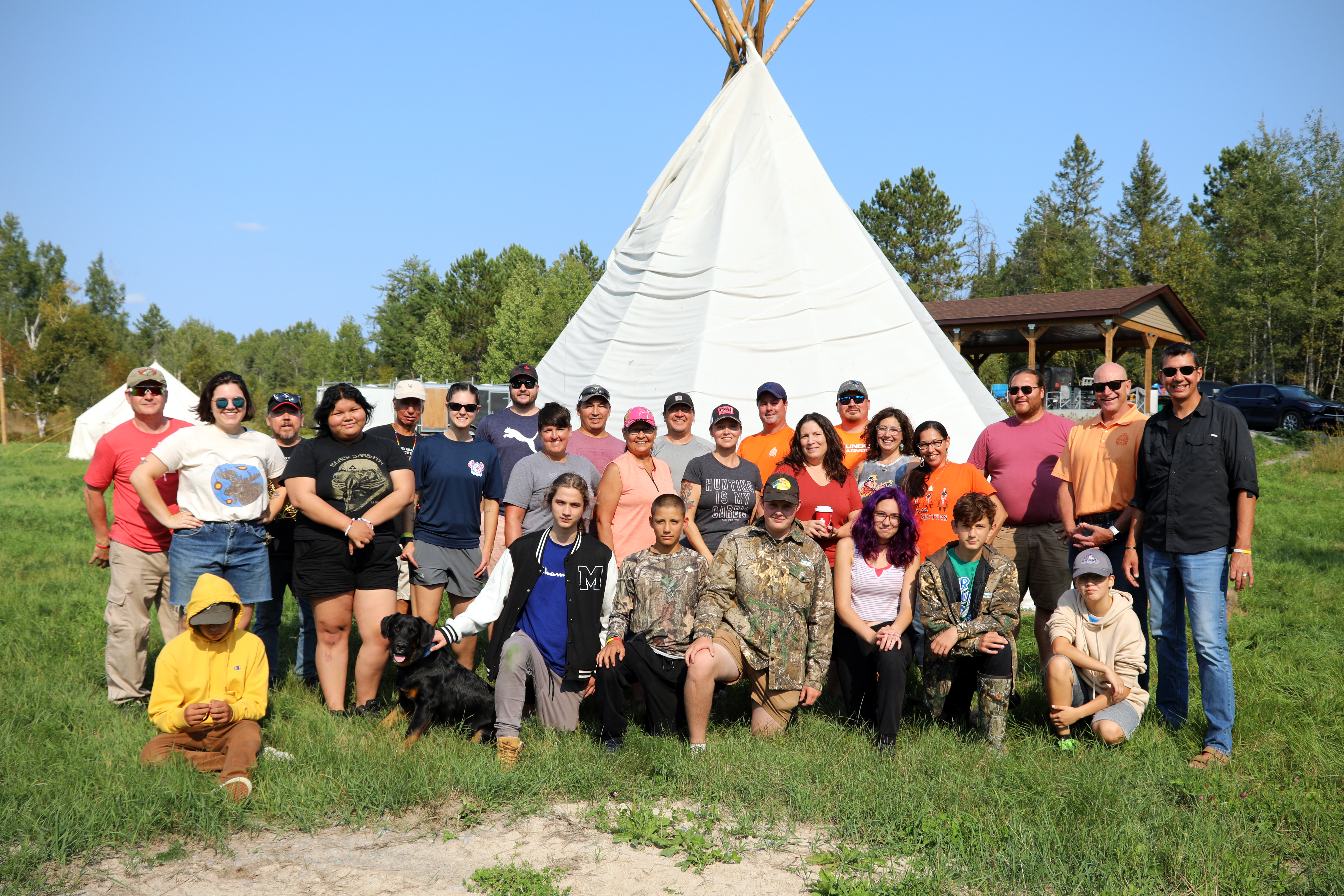 group of people standing in front of tipi