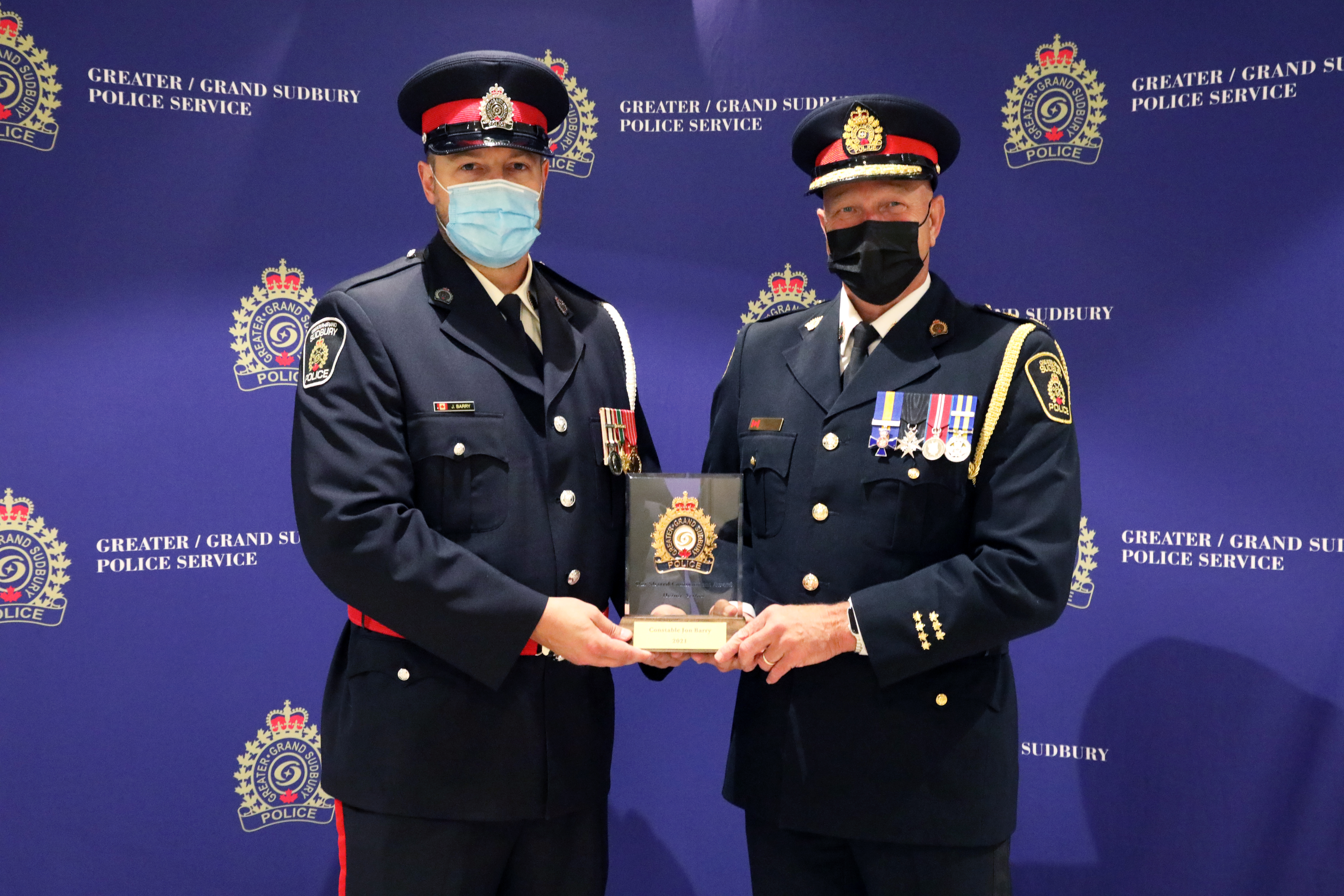 Police Officer and Chief holding award