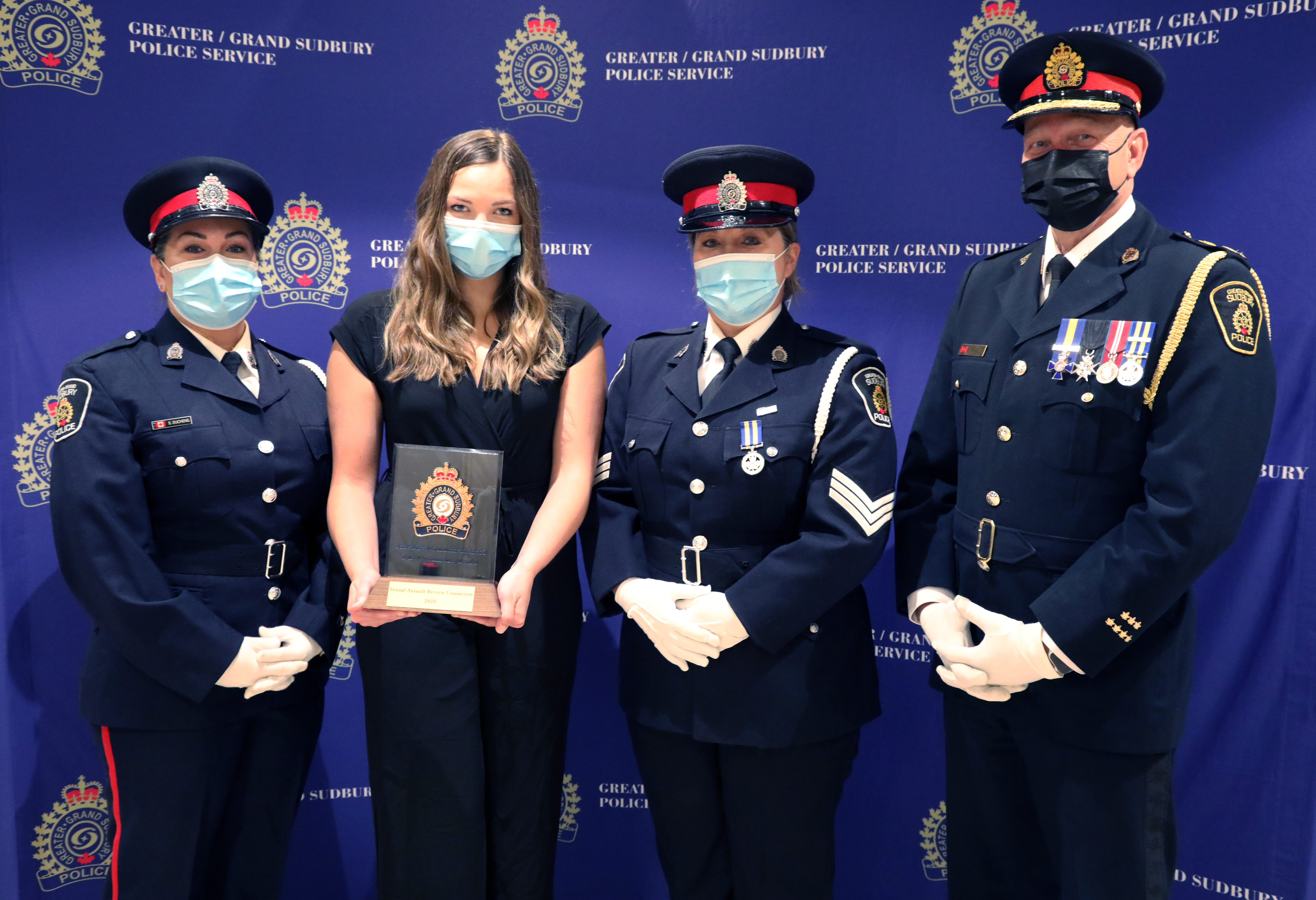 officers and civilian standing with chief of police