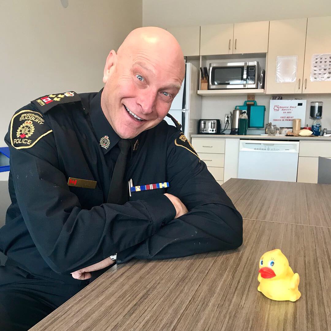 Chief of Police in uniform smiling at rubber duck