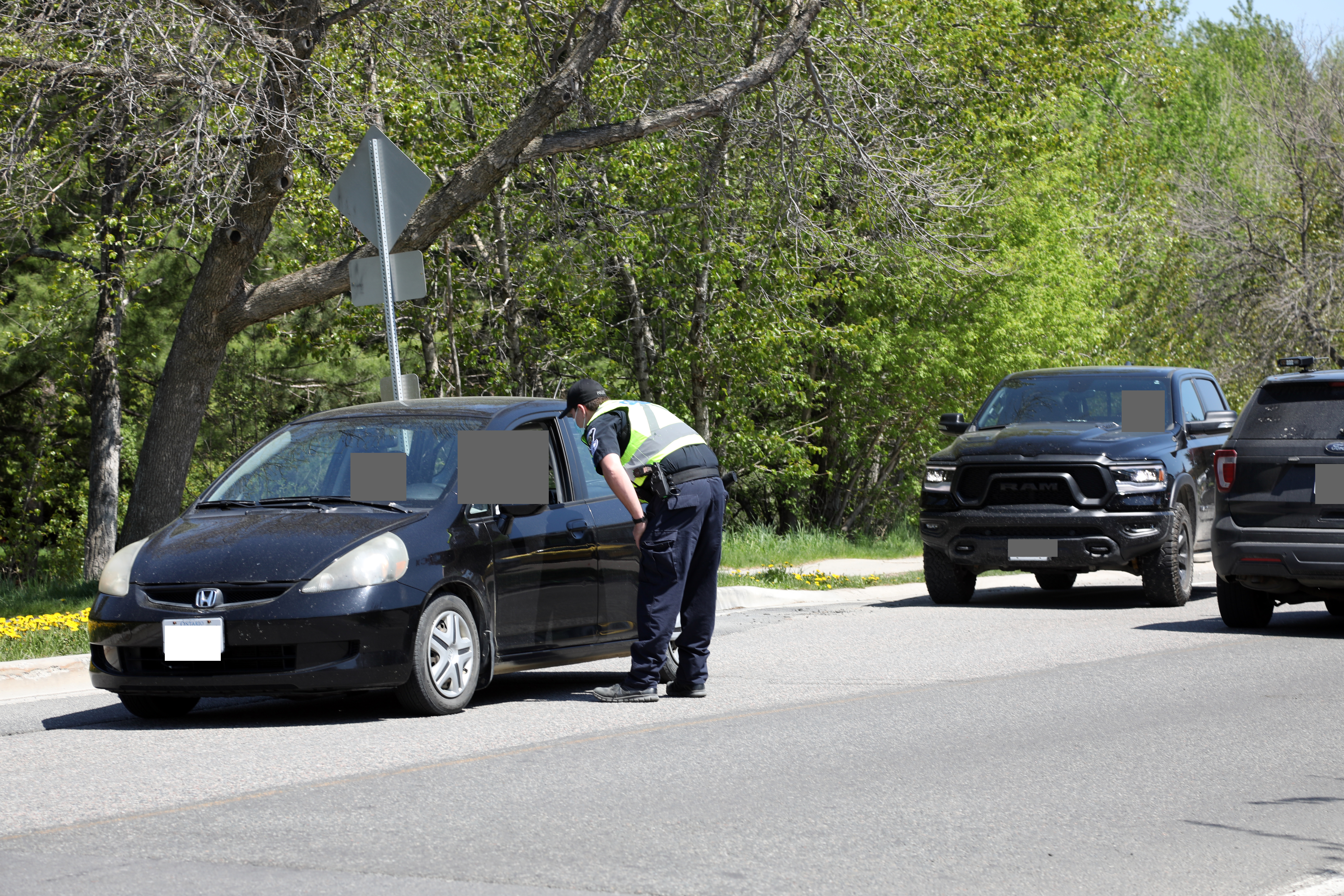 Officer standing at window of vehicle on road