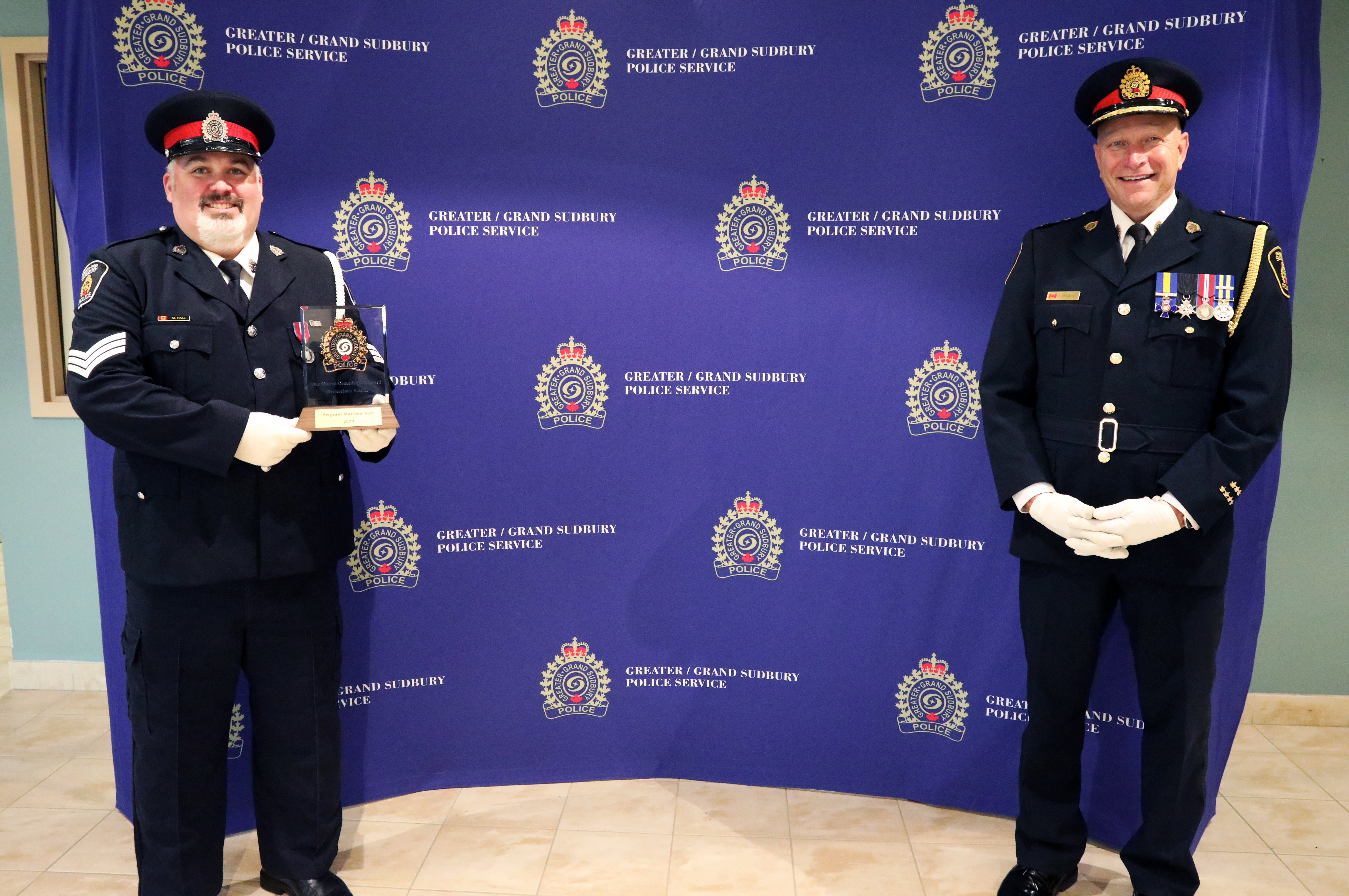 two men in uniform holding award
