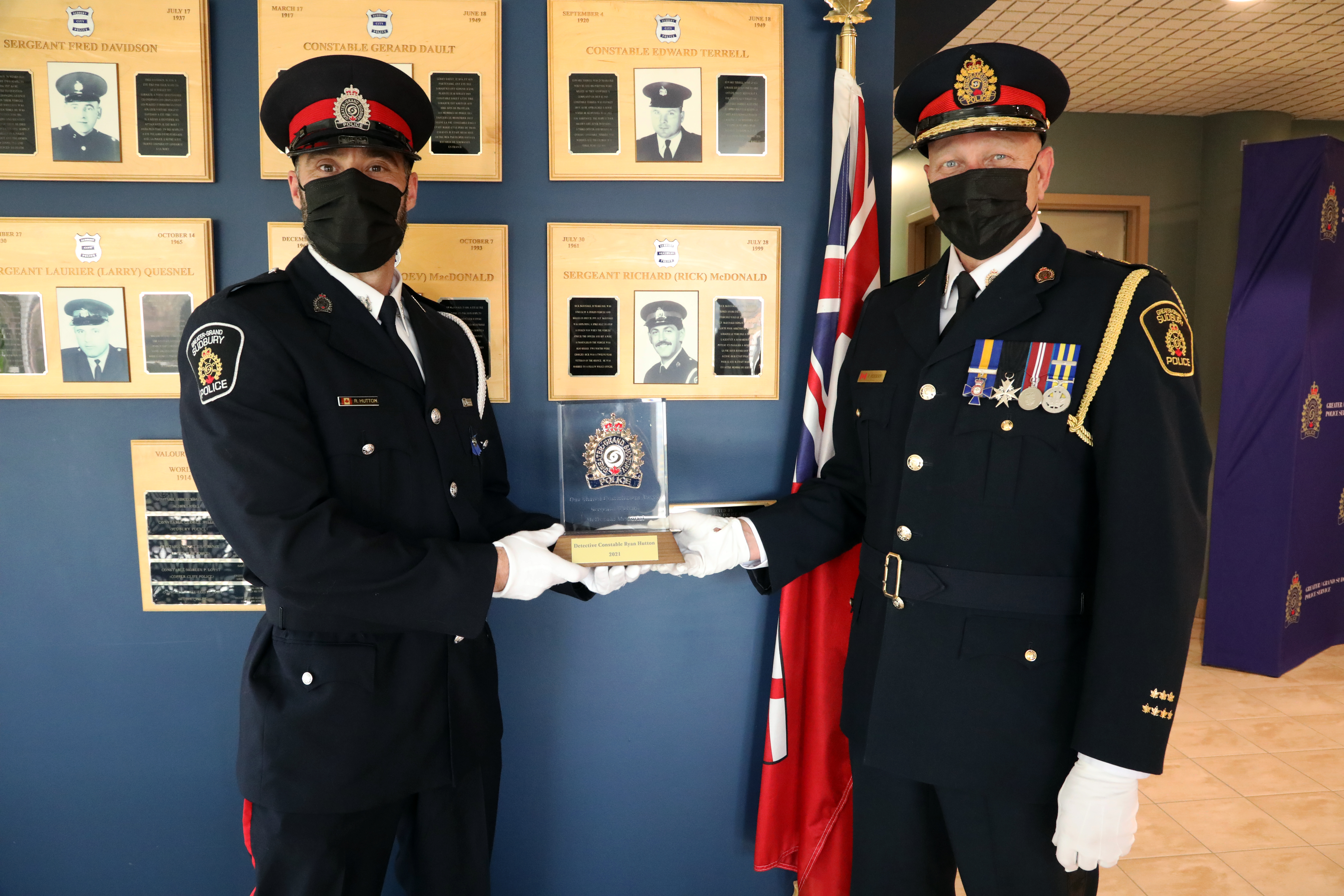 Two police officers holding award