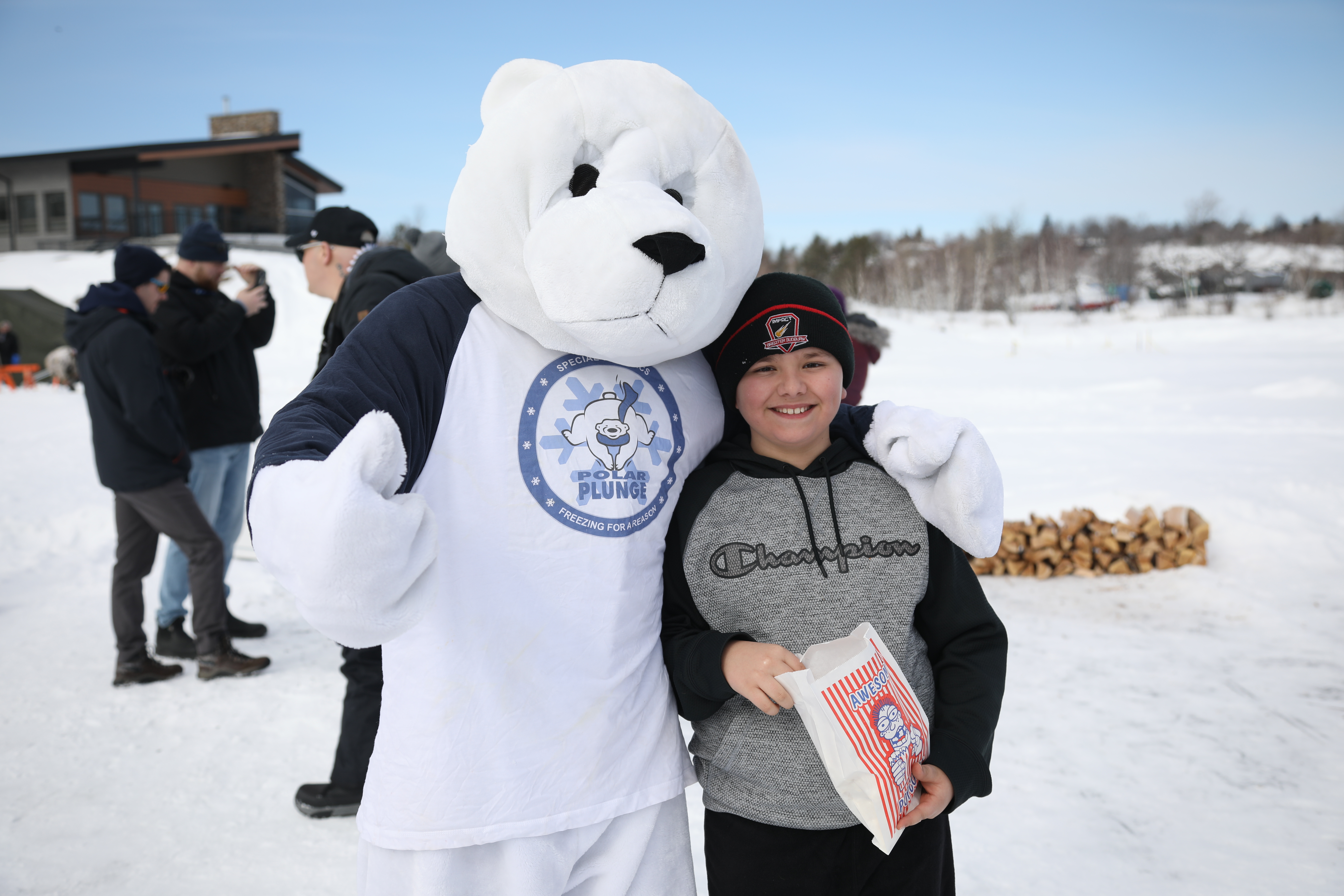 Plungee the Polar Bear mascot standing beside child