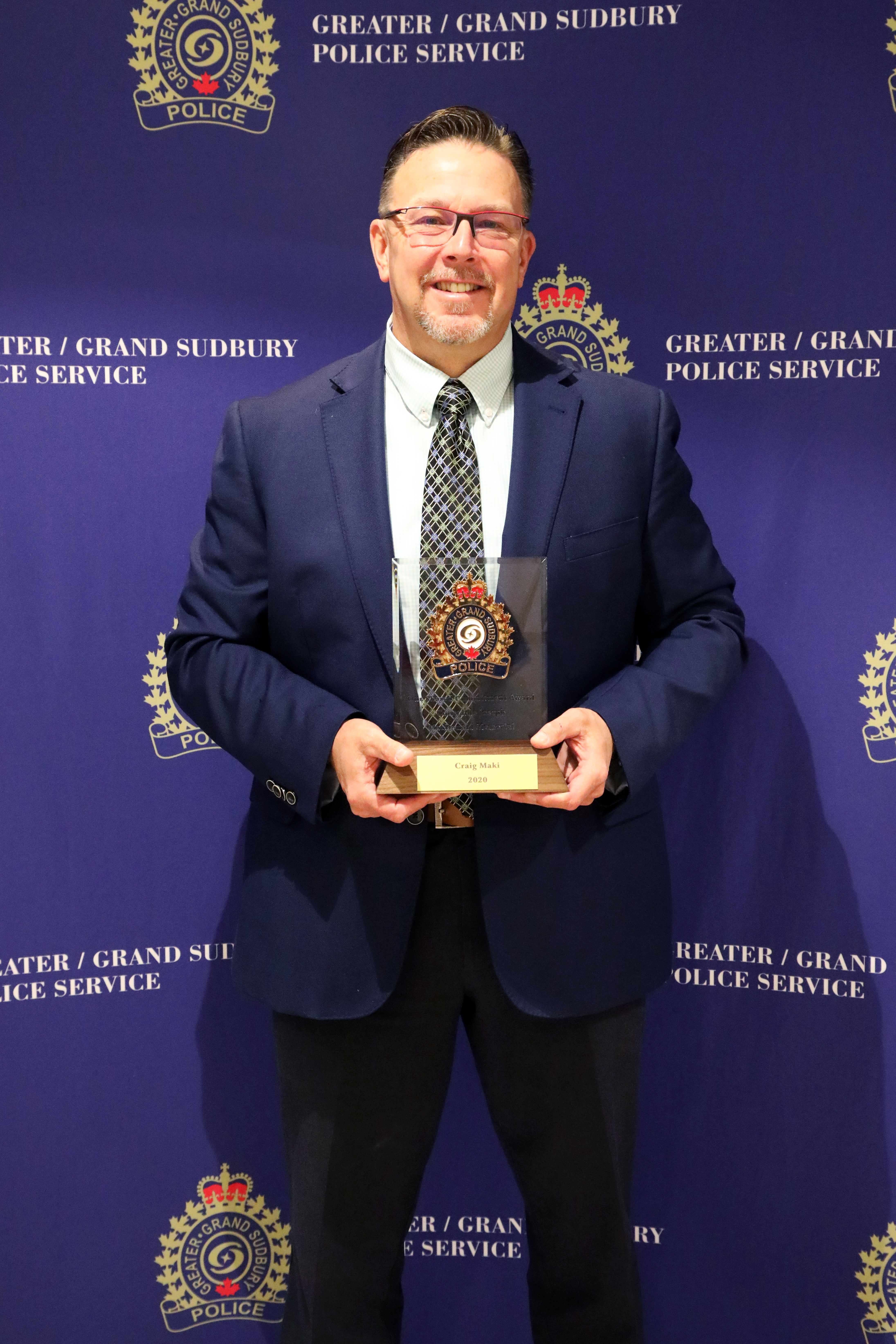 man smiling and holding award