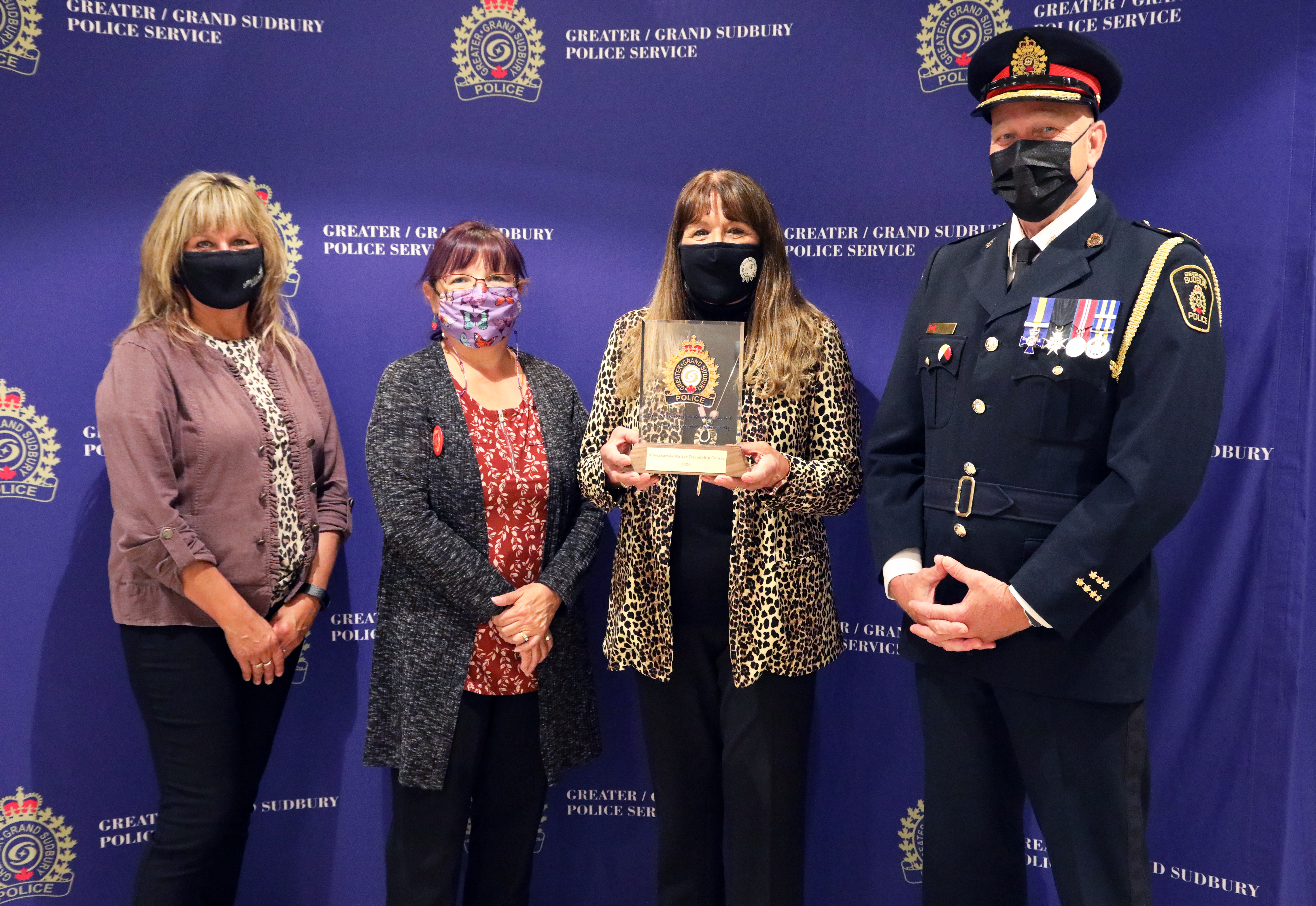 women and Chief standing holding an award