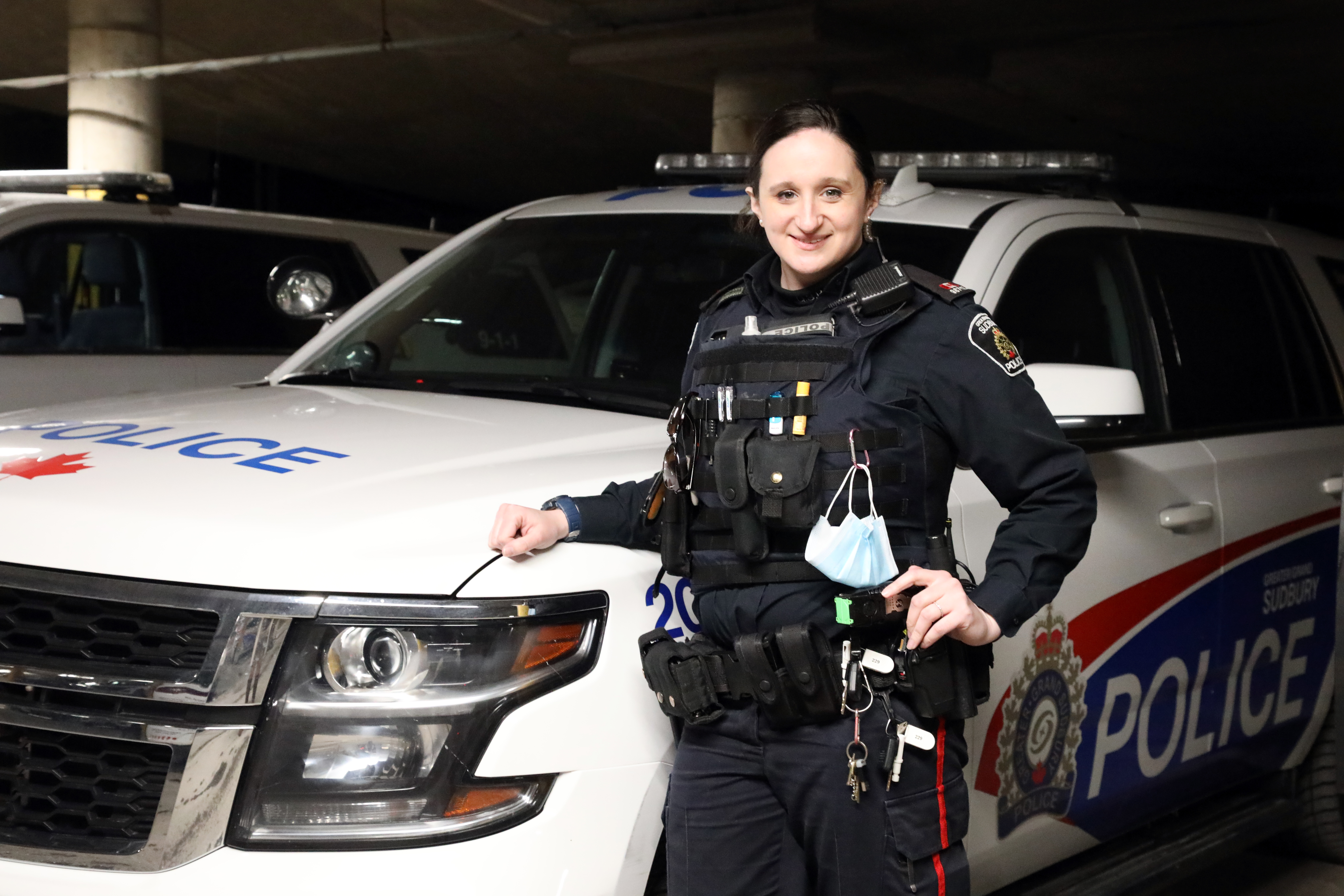 female officer standing beside cruiser