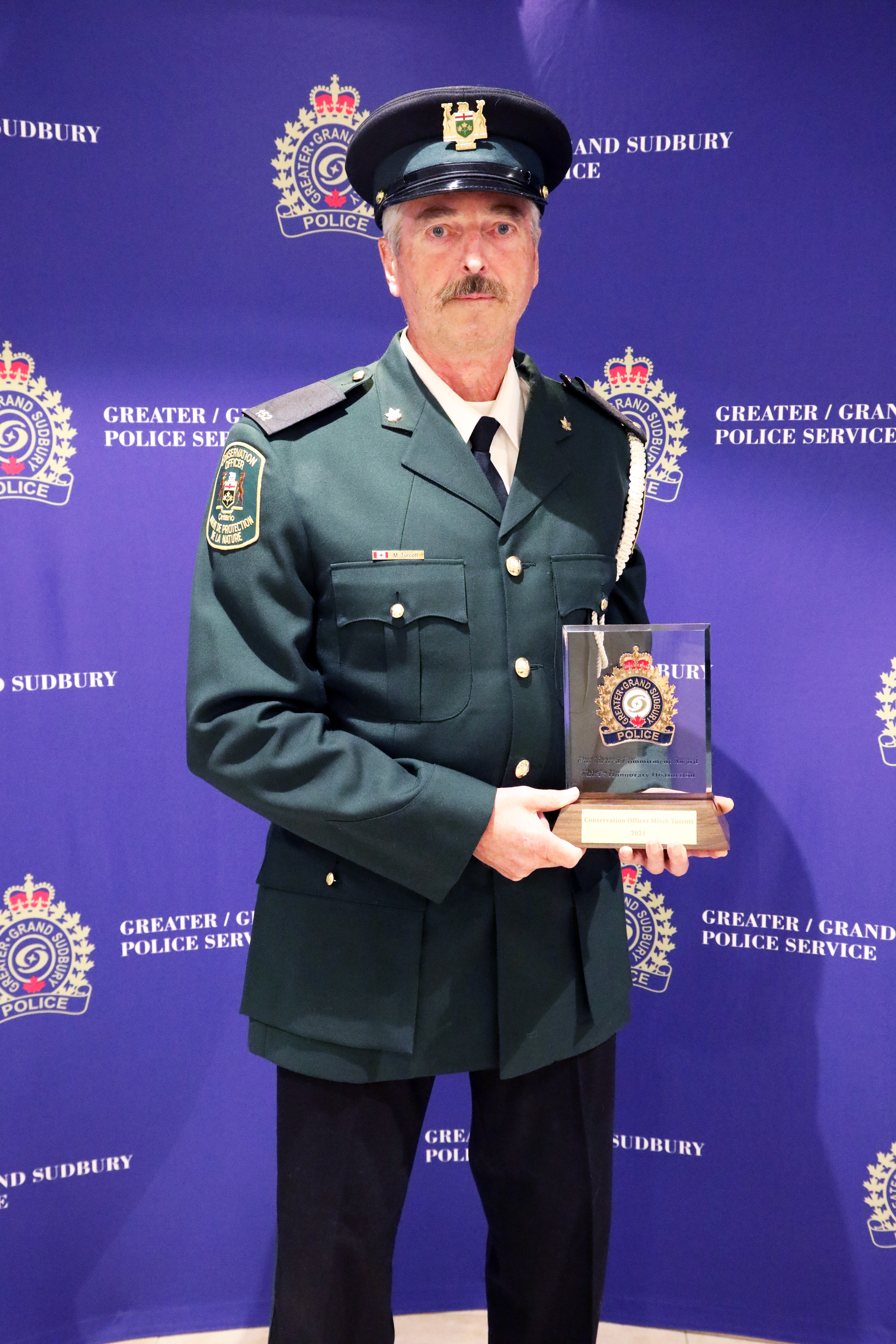 man in uniform holding award