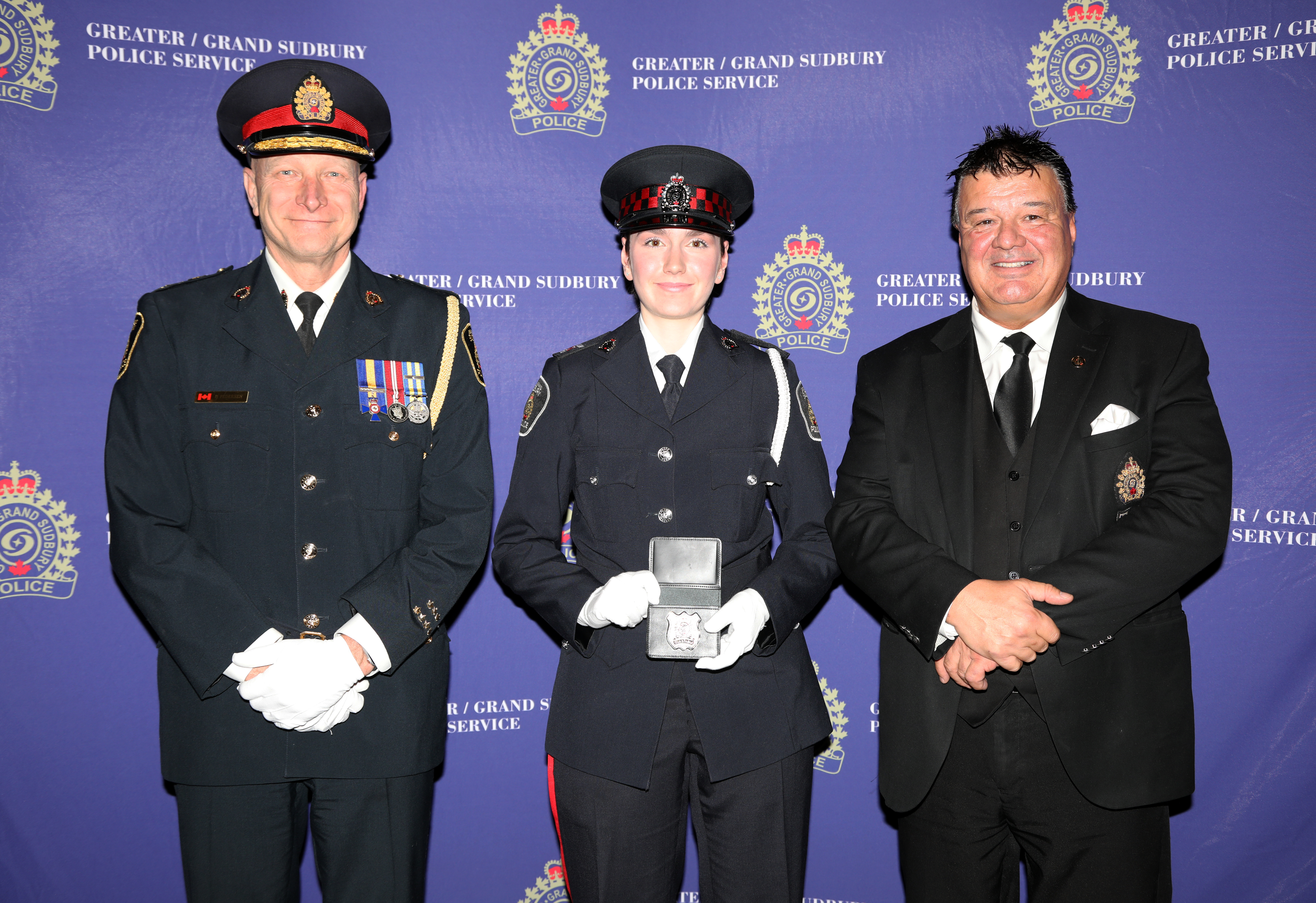 auxiliary officer in uniform holding badge