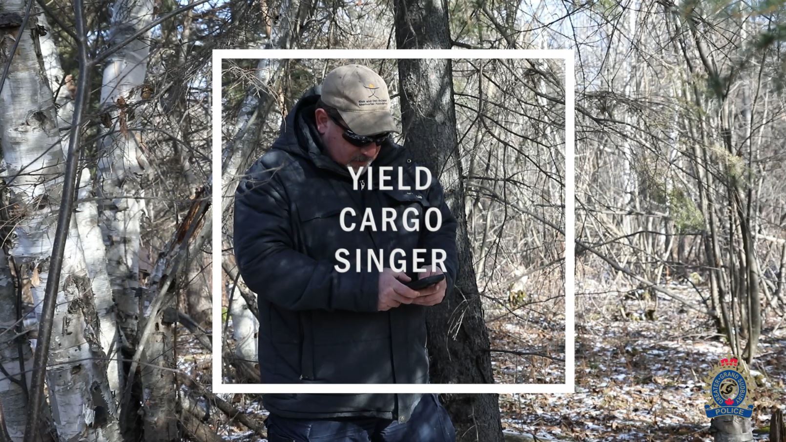 man standing in woods on phone 