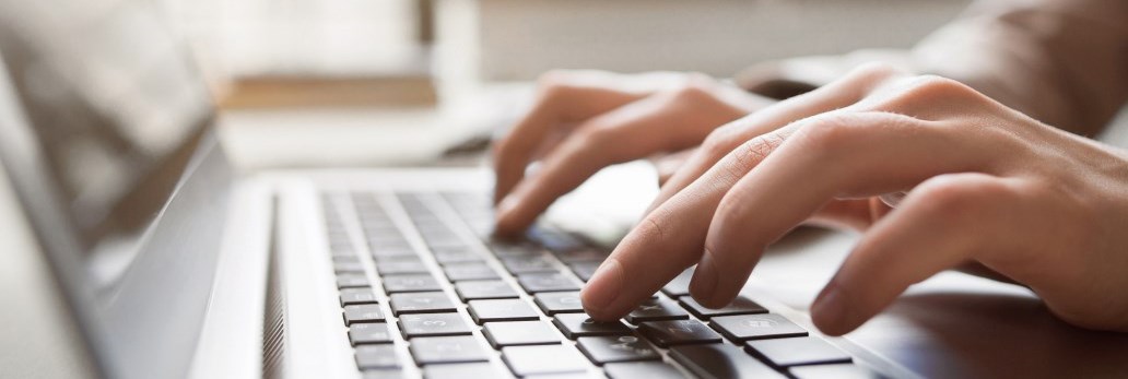 hands typing on computer keyboard