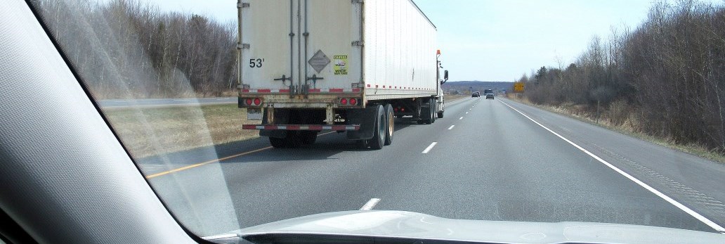 view from vehicle of transport truck driving on highway