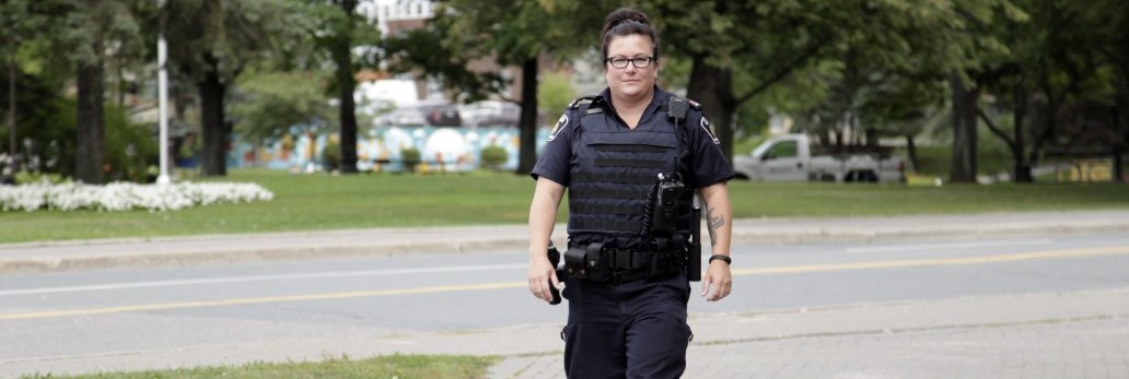 Officer walking outside along the sidewalk