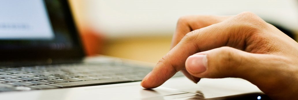 fingers on keyboard of laptop