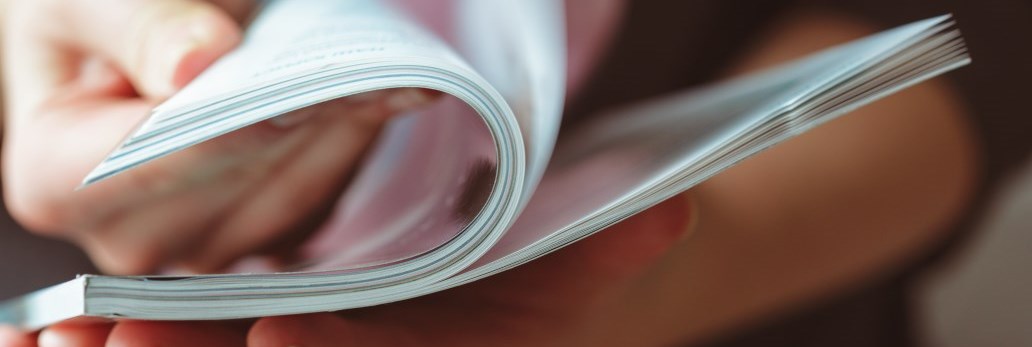 person flipping through printed publication